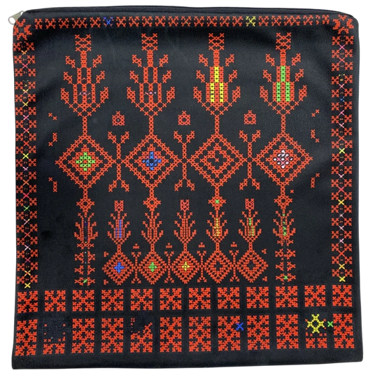 A square black zippered pouch featuring a vibrant, traditional geometric cross-stitch pattern in red, orange, yellow, green, and blue thread, photographed flat against a white background.