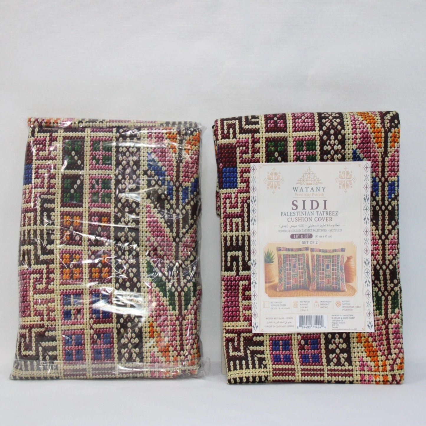 Two folded woven cushion covers with a colorful geometric pattern, shown side by side against a plain light background. The left cushion cover is sealed in clear plastic, and the right one has a white paper label attached.