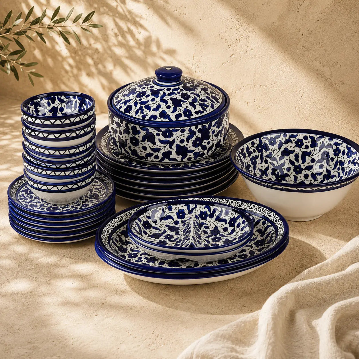 Set of blue and white ceramic dishes on a beige surface with natural light.