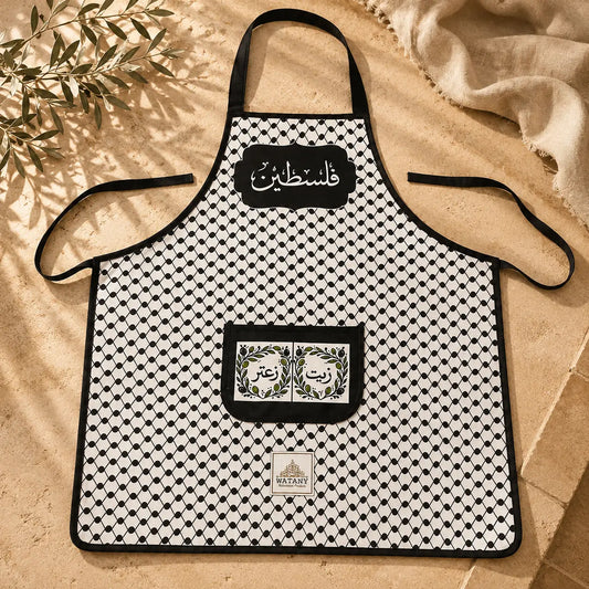 Black and white patterned apron with branding on a beige surface