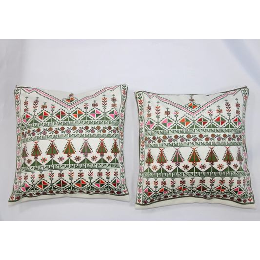 Two square throw pillows with intricate traditional embroidery in green, red, and pink on an off-white background, displayed side-by-side against a plain white backdrop.