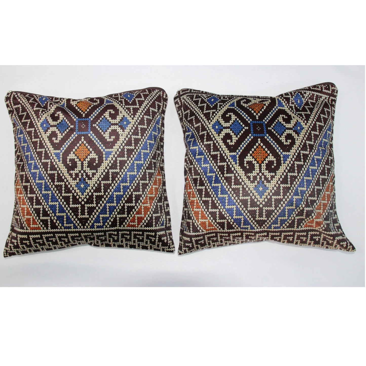 Two square decorative throw pillows with intricate geometric tribal patterns in brown, blue, orange, and cream, displayed side-by-side against a plain white background.