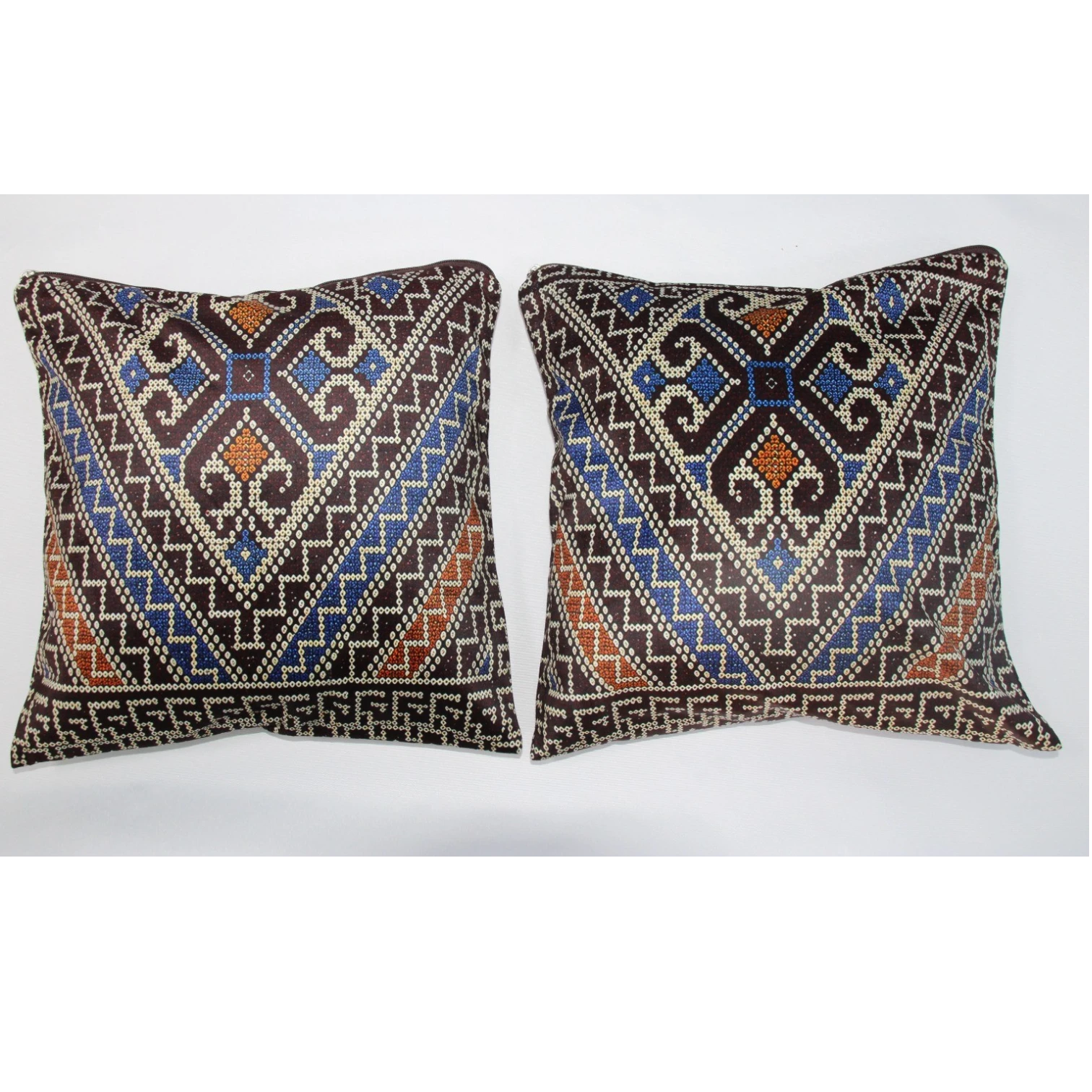 Two square decorative throw pillows with intricate geometric tribal patterns in brown, blue, orange, and cream, displayed side-by-side against a plain white background.